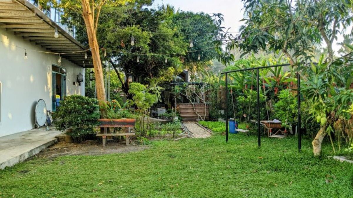 Sân vườn villa với xích đu và cây trái — không gian sinh hoạt chung ngoài trời