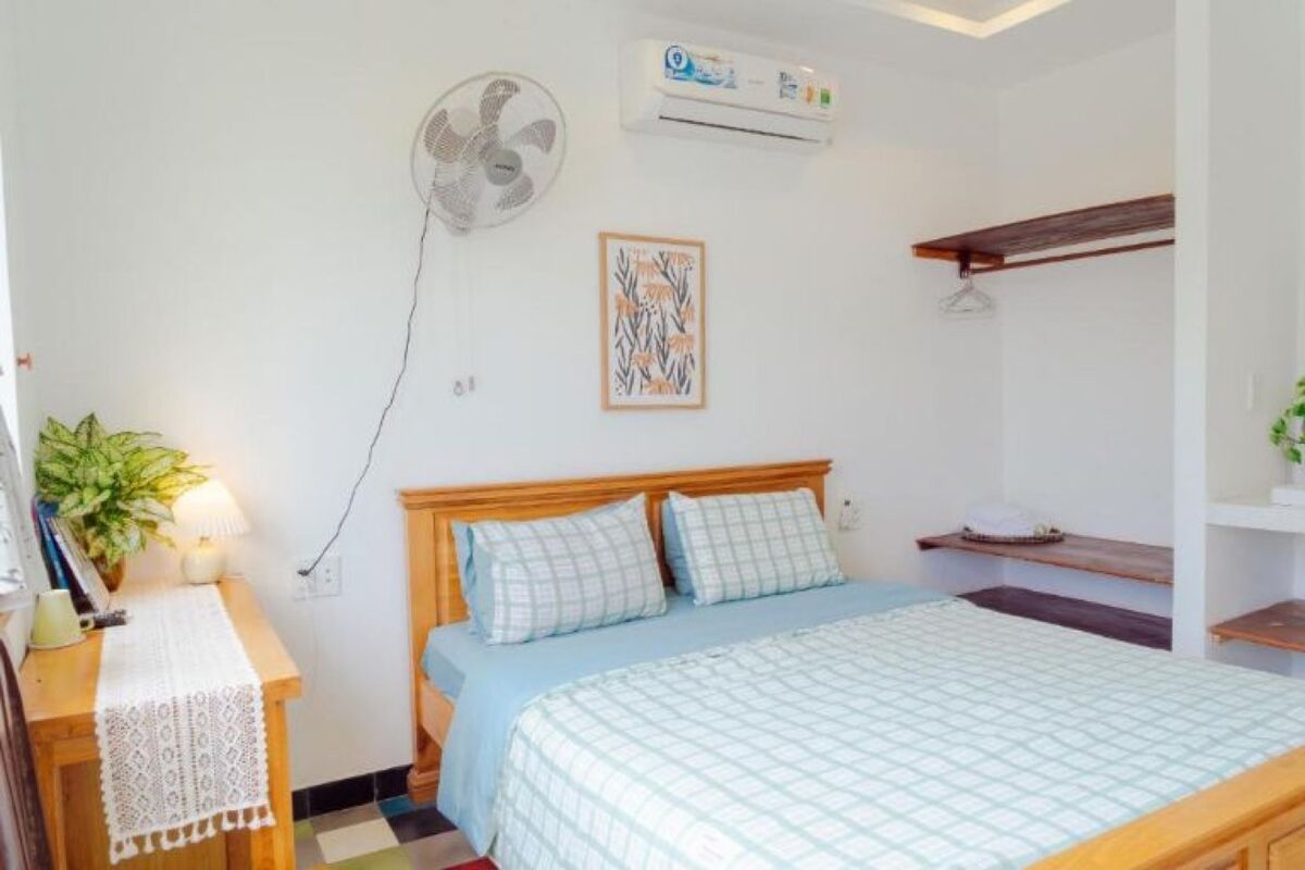 Phòng ngủ villa với cửa kính lớn nhìn ra vườn